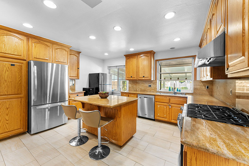Kitchen with stainless steel appliances, a granite island, and barstool seating