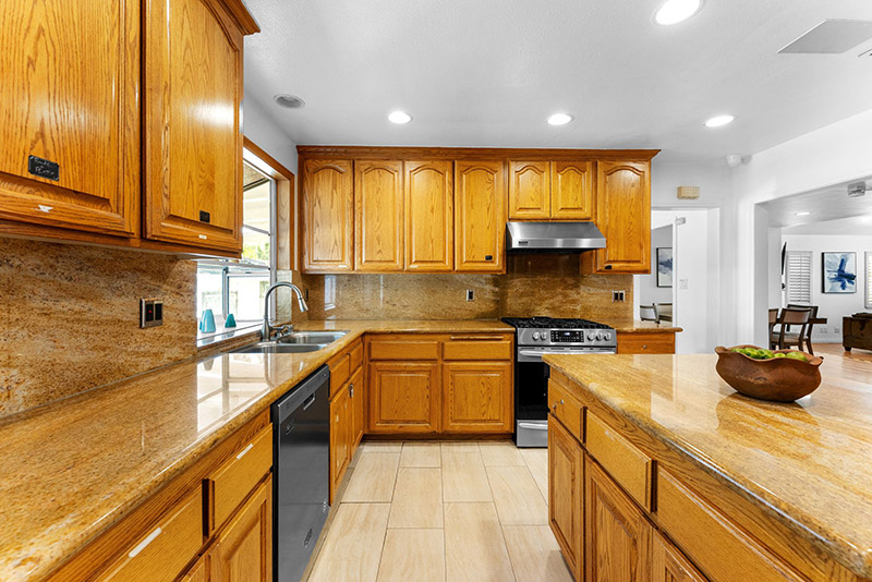 Kitchen with granite countertops, tile backsplash, and a gas range