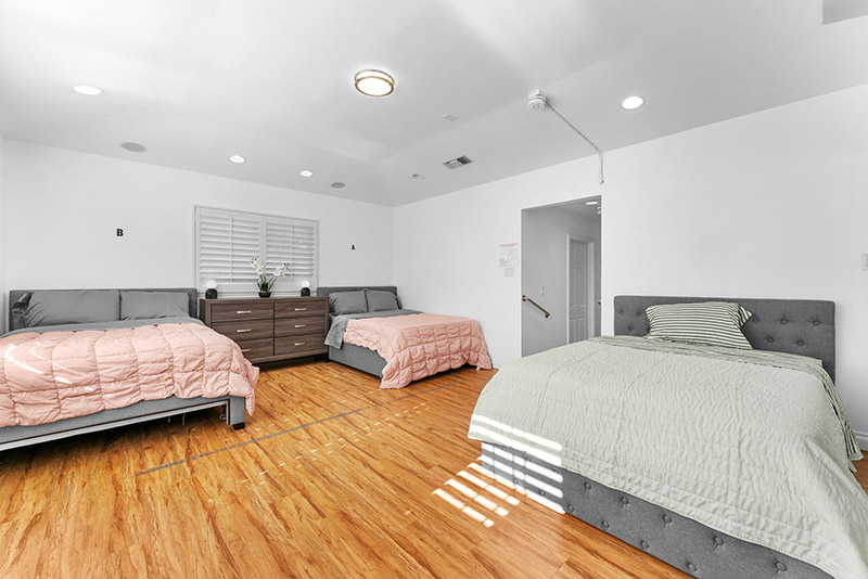 Shared bedroom with three beds, labeled for individual residents
