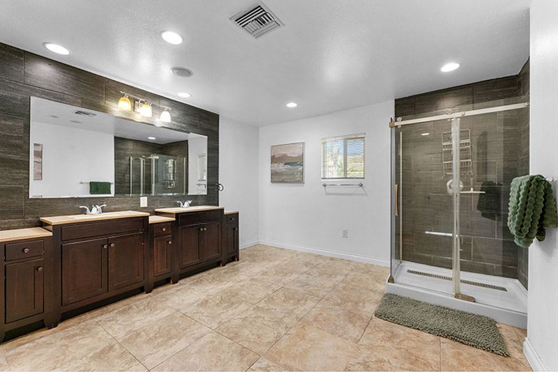 Bathroom with a dual vanity and a glass-enclosed walk-in shower