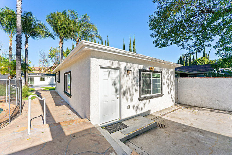 Exterior of a detached guest cottage with a covered walkway