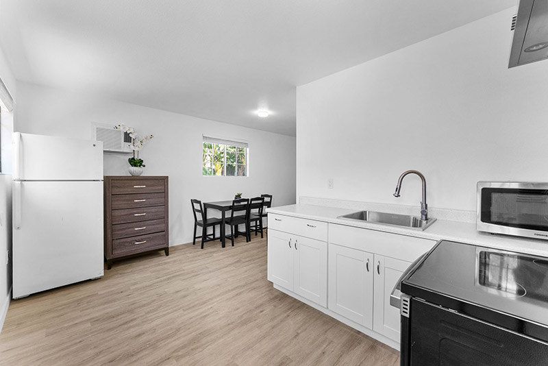 Kitchen and dining area in the guest cottage, with a black dining set and stainless appliances