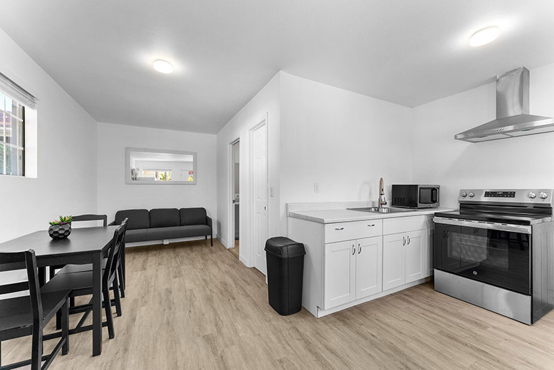 Living and kitchen area in the guest cottage, with a dining table and stainless appliances