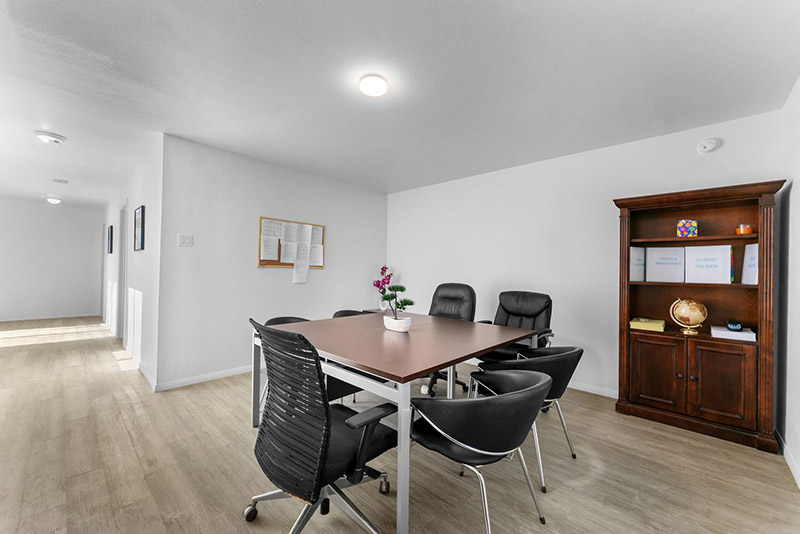 Conference room with a wood table, leather chairs, and a bookcase