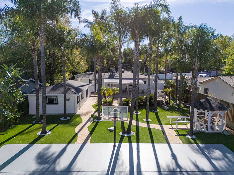 Aerial view of the backyard basketball court, guest house, and pool area