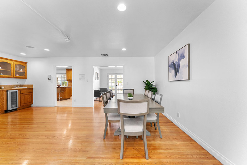 Dining area with a wet bar and wine fridge, opening onto the kitchen and a sitting room